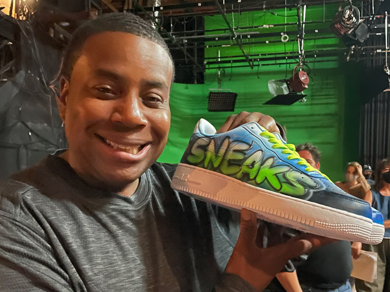 Kenan Thompson holding Sneaks sneakers 