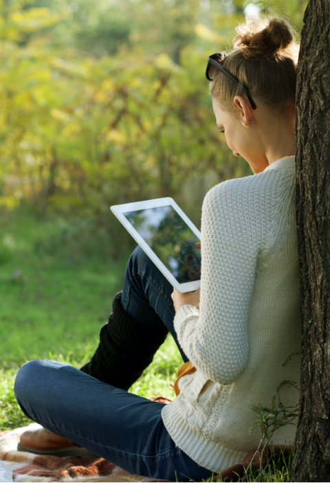 woman outside with tablet in her hand, watching a video